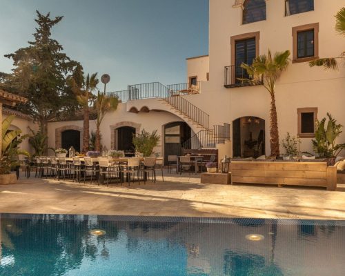 The rustic stone facade of Masia Victoria, showcasing its historic charm and Mediterranean architecture.