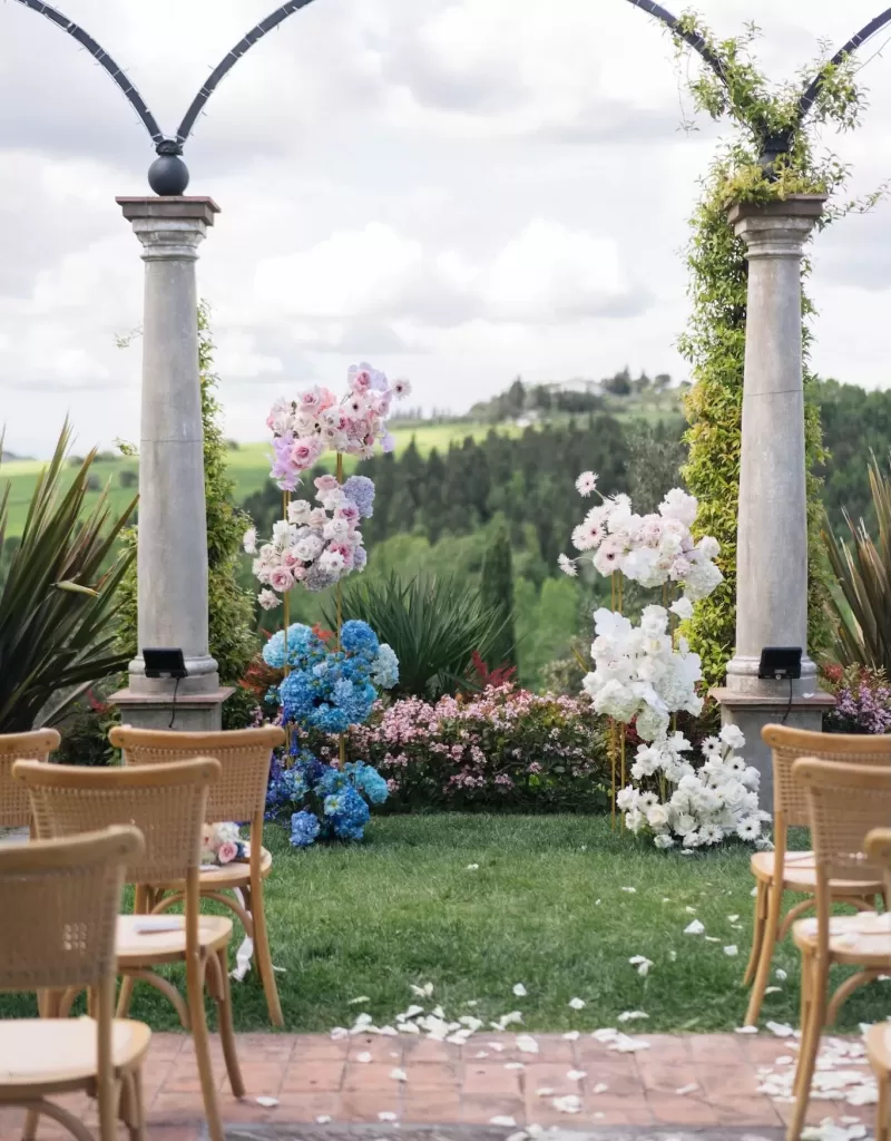Scenic aisle view at Tenuta Corbinaia after the ceremony with scattered white petals and countryside in the distance.